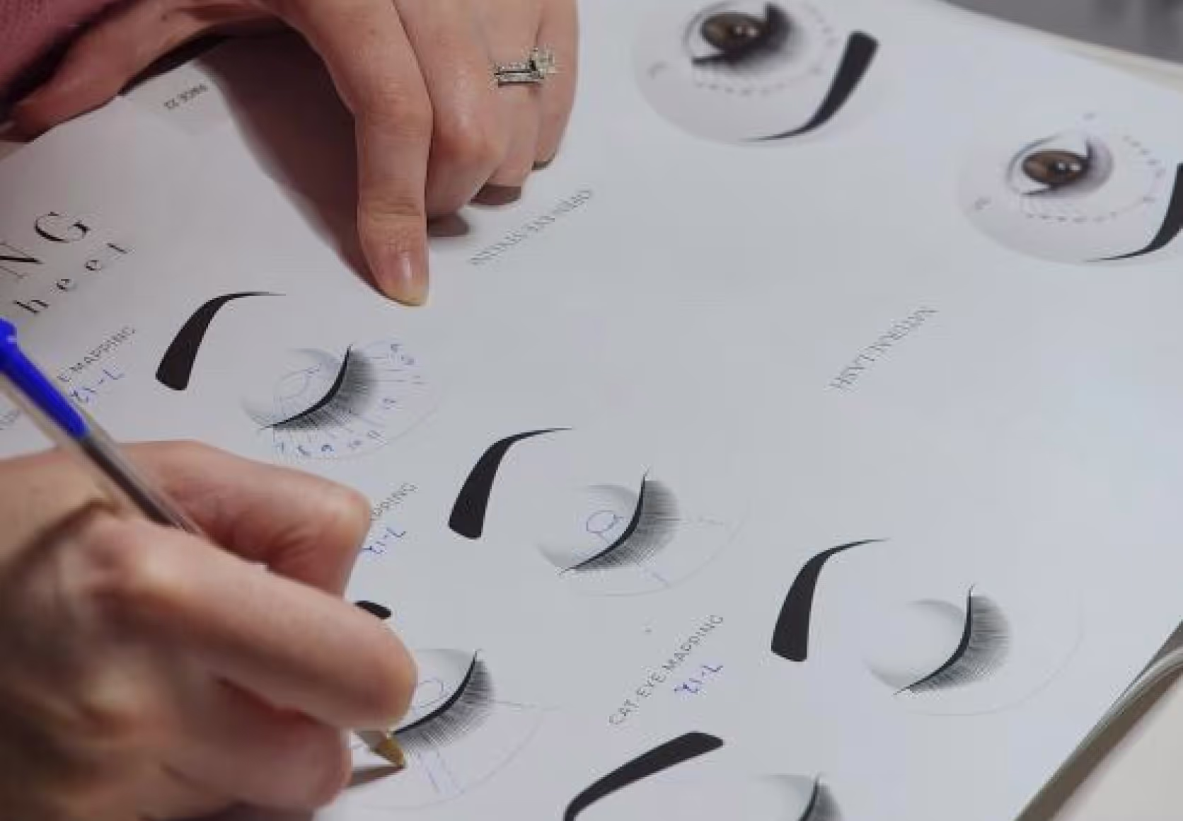 Student drawing lash styles during training.