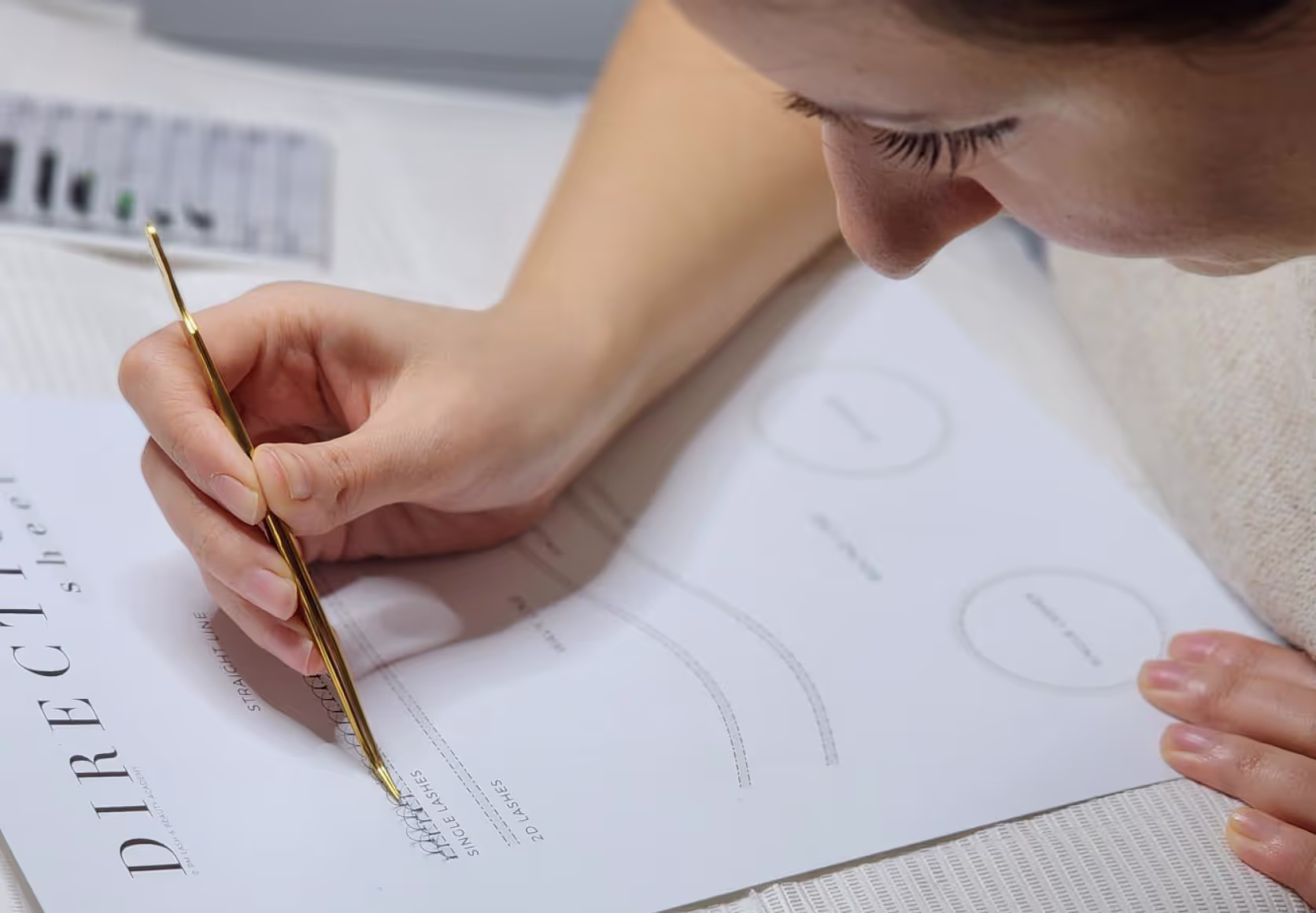 Student practicing lash styles on practice sheet.