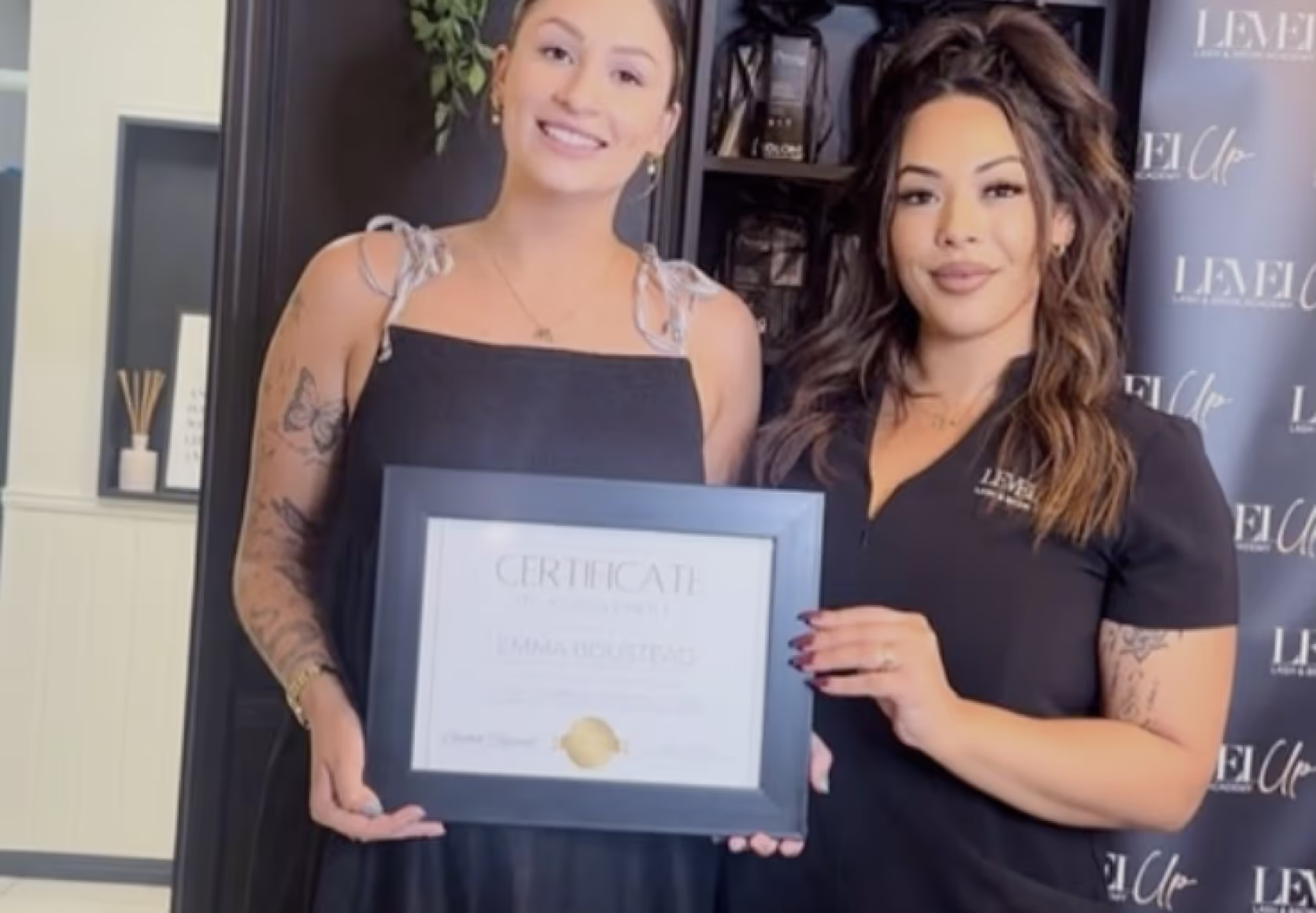 Accredited lash educator with student holding lash extension training certificate after course completion.