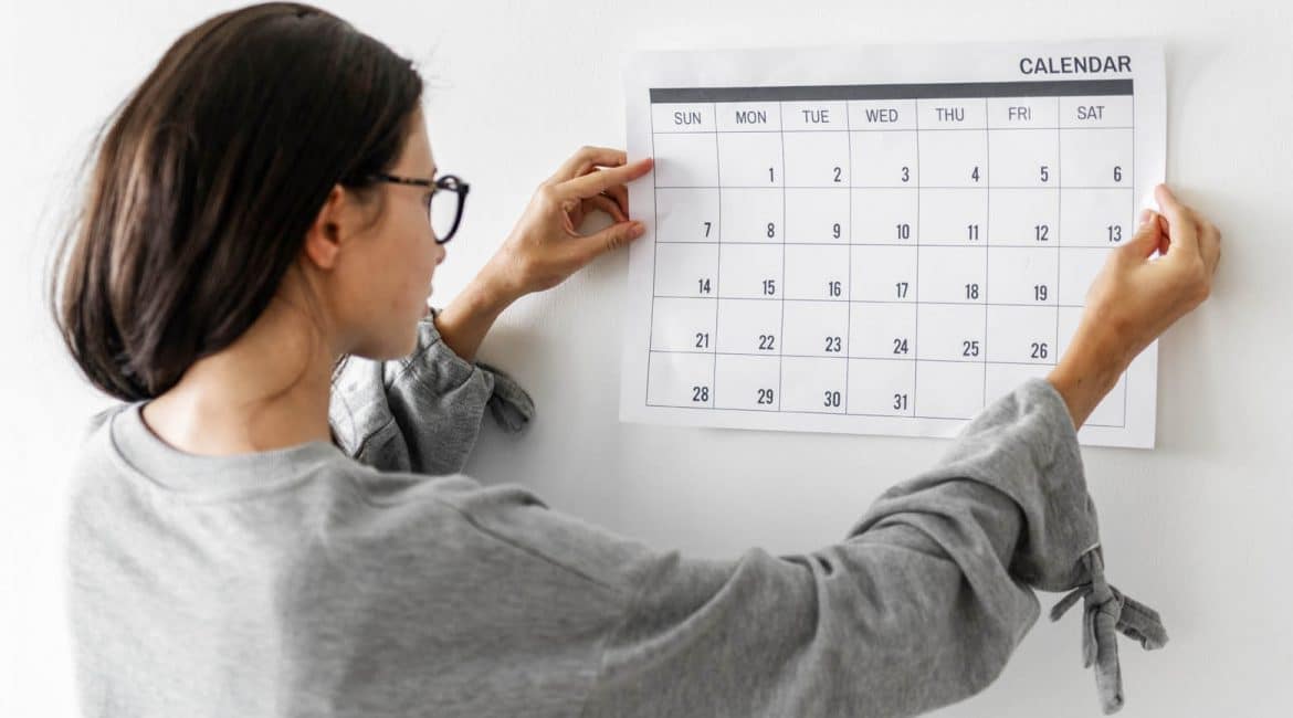 How to efficiently manage your time when running your lash business. Women checking the calendar .