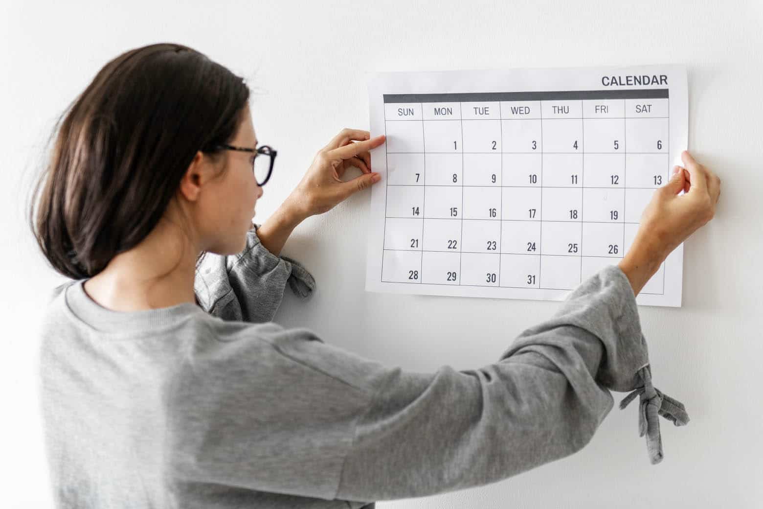 How to efficiently manage your time when running your lash business. Women checking the calendar .